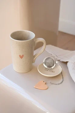 Tasse à thé en porcelaine avec soucoupe et boule à thé