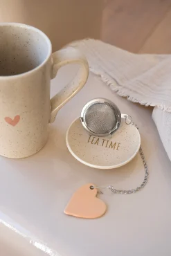 Tasse à thé en porcelaine avec soucoupe et boule à thé